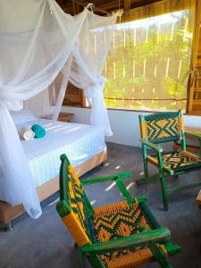 埃尔扎伊诺Frana Lodge的一间卧室配有两把椅子、一张床和窗户