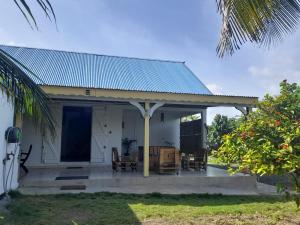 圣弗朗索瓦Maison bord de mer à 100 m的蓝色屋顶的白色小房子