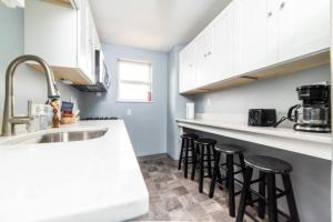 匹兹堡-- AGH Walkable - Free Parking - Washer & Dryer --的厨房配有白色橱柜和黑色吧台凳