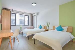 义乌朵朵酒店公寓(义乌国际商贸城店)的酒店客房配有两张床和一张书桌