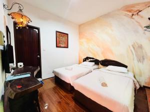 古晋古晋海滨旅舍的酒店客房设有两张床和电视。