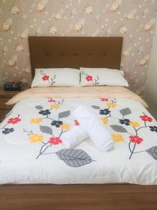 碧瑶Brenthill Condominium的一张床上的白色毯子,上面有鲜花