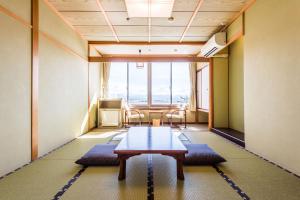 加贺Ooedo Onsen Monogatari Nagayama的客房设有桌椅和大窗户。
