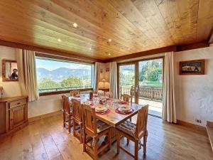 孔布卢Chalet Combloux, 6 pièces, 10 personnes - FR-1-560-88的一间带桌子和大窗户的用餐室