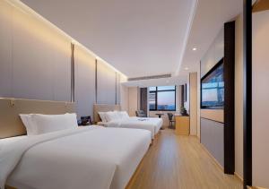 张家界Zhangjiajie Hero Boutique Hotel的酒店客房配有两张床和一张书桌