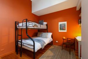 墨尔本Warburton's Loft的一间卧室拥有橙色的墙壁和一张双层床。
