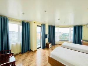 Hòa ÐìnhDREAM HOTEL Bắc Ninh的一间卧室设有两张床和蓝色窗帘