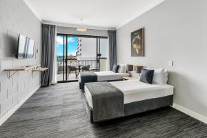 凯恩斯Gilligan's Hotel & Resort Cairns的酒店客房设有两张床和一个阳台。