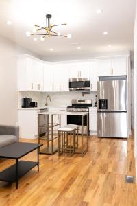 布鲁克林Misbau home的厨房配有白色橱柜和不锈钢冰箱