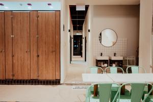 新加坡Code Hostel Singapore的配有桌椅和镜子的客房