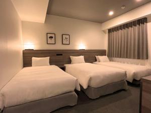 札幌Best Western Sapporo Odori Koen的一间卧室配有两张带白色床单的床