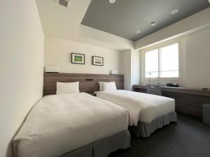札幌Best Western Sapporo Odori Koen的一间卧室设有两张床和窗户。