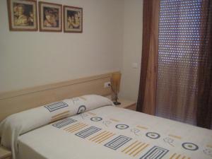 圣卡洛斯拉腊皮塔海岛公寓的小卧室配有一张床和床罩