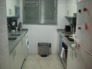 圣卡洛斯拉腊皮塔海岛公寓的小厨房配有白色橱柜和水槽