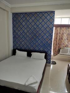 迪马普尔HOTEL EAST INN DIMAPUR的一间卧室配有一张蓝色墙床