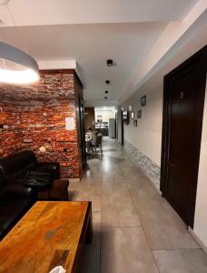埃里温Loft Host Yerevan的长长的走廊,有砖墙和桌子