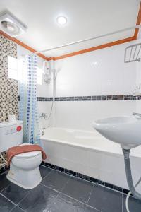 芭东海滩Patong Social Hotel & Restaurant的带浴缸、卫生间和盥洗盆的浴室