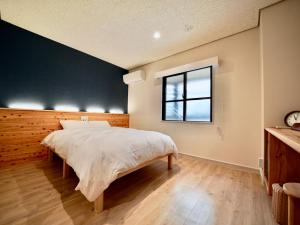 石垣岛Hotel Ishigaki and Chikonkiya的一间卧室设有一张大床和一个窗户。