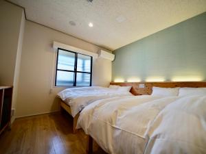 石垣岛Hotel Ishigaki and Chikonkiya的带窗户的客房内的两张床