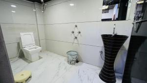乌贾因PALLAV GUEST HOUSE的白色的浴室设有卫生间和水槽。