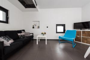 DragoveVilla Gordan - Happy Rentals的客厅配有黑色沙发和蓝色椅子