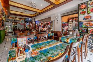 芭东海滩Patong Social Hotel & Restaurant的一间带桌椅的用餐室和一间餐厅