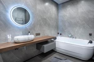阿拉木图Apart Hotel Colibri的带浴缸、水槽和镜子的浴室