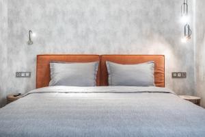 阿拉木图Apart Hotel Colibri的一张带木制床头板的床和两个枕头