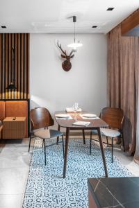 阿拉木图Apart Hotel Colibri的一间位于地毯上的带桌椅的用餐室