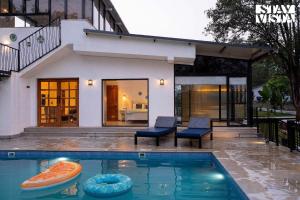 卡尔贾特StayVista's The Oasis - Serene Retreat with Private Pool, Lawn & Gazebo的房屋前的游泳池