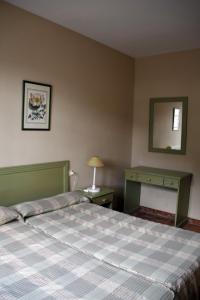 格拉茨莱马Villa Turística de Grazalema的一间卧室配有一张床、一张桌子和一面镜子