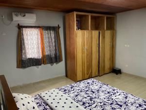 克里比La Maison Du Voyageur的一间卧室配有一张床和一个木制橱柜