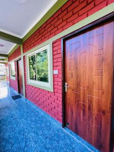 瑞诗凯诗Shiv Shakti Yogpeeth Cottages的红砖墙,带有木车库门