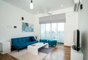 科伦坡Hotel Style Colombo Studio Apartment的客厅配有蓝色的沙发和电视