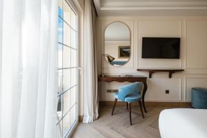 Hal GhaxiakPalazzo Castagna Boutique Hotel的卧室配有书桌和靠窗的蓝色椅子