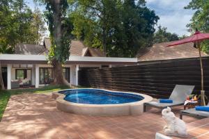 清莱 传奇清莱度假村的一座带房子的庭院内的游泳池