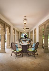 瓜廖尔Taj Usha Kiran Palace, Gwalior的一间带桌椅的用餐室