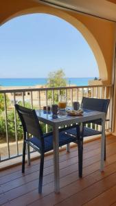 阿尔加约拉Studio standing classé avec terrasse vue mer " les pieds dans l'eau " à Algajola的海景门廊上的桌椅