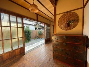 镰仓市古民家の宿 鎌倉楽庵的一间设有梳妆台和滑动玻璃门的房间