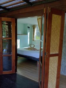 麦岛Koh Mak Living的卧室设有一张床铺,可通过一扇开放式门欣赏到美景