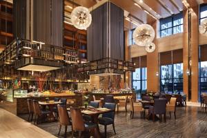 黄石黄石富力万达嘉华酒店的餐厅设有桌椅和吊灯。