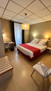 罗纳河畔的图尔农Logis Hôtel Restaurant Azalées的一间卧室配有一张带红色毯子的大床