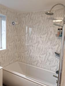 贝克斯利Charming 5 Bedroom House in Bexley的带浴缸和玻璃淋浴间的浴室。