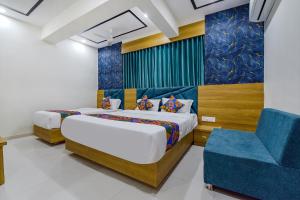 艾哈迈达巴德HOTEL GREEN TREE的一间卧室配有两张床和一张蓝色椅子