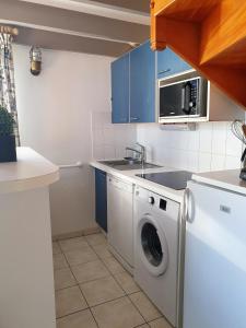 滨海拉库阿尔德Duplex 6-7 p Résidence proche plage的厨房配有洗衣机和蓝色橱柜。