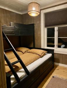 内斯比恩Apotekbygget的一间卧室配有双层床和窗户。