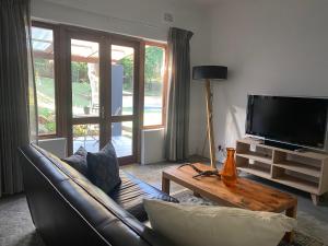 GillittsChurchill Cottage的客厅配有真皮沙发和电视