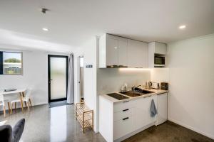 克莱夫Modern Studio near Clive River的厨房配有白色橱柜和桌子