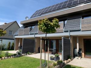 比苏姆Zuhause am Meer的旁边设有太阳能电池板的房子