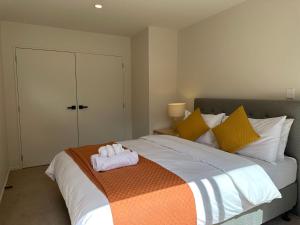 奥克兰Northshore Charming 4 bedrooms的一间卧室配有一张床,床上有毛巾
